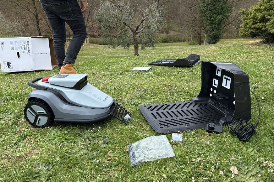 TerraMow V1000 steht neben den einzelnen Teilen des Lieferumfangs
